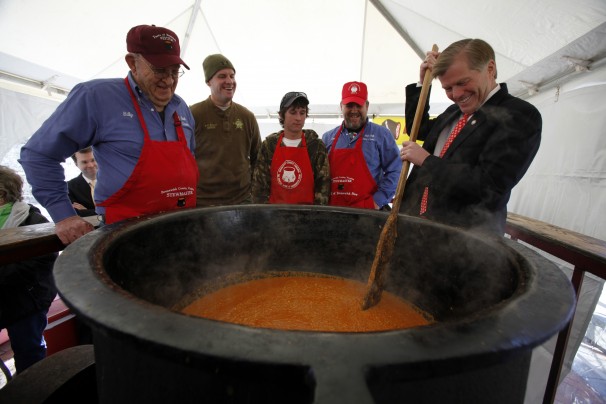 BOB BROWN/Associated Press - Red Oak Stew Crew member Billy Waller, left, watches Virginia Gov. Robert F. McDonnell wield the paddle at last year’s Brunswick Stew Day in Richmond.